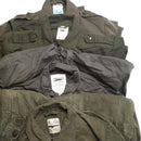 Stack of original Dutch Army olive green overall suits with collars and labels visible, folded on a white background