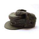 Vintage genuine Austrian Army winter cap in olive with ear flaps, visor, and an insignia badge on front.