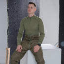 Man wearing genuine Czech army M85 thermal liner trousers sitting on white block in studio environment