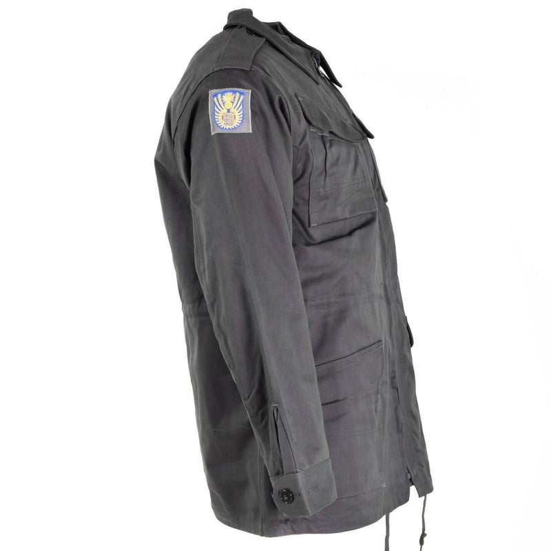 Side view of genuine Danish Army M71 combat jacket in military grey with sleeve patch and multiple pockets