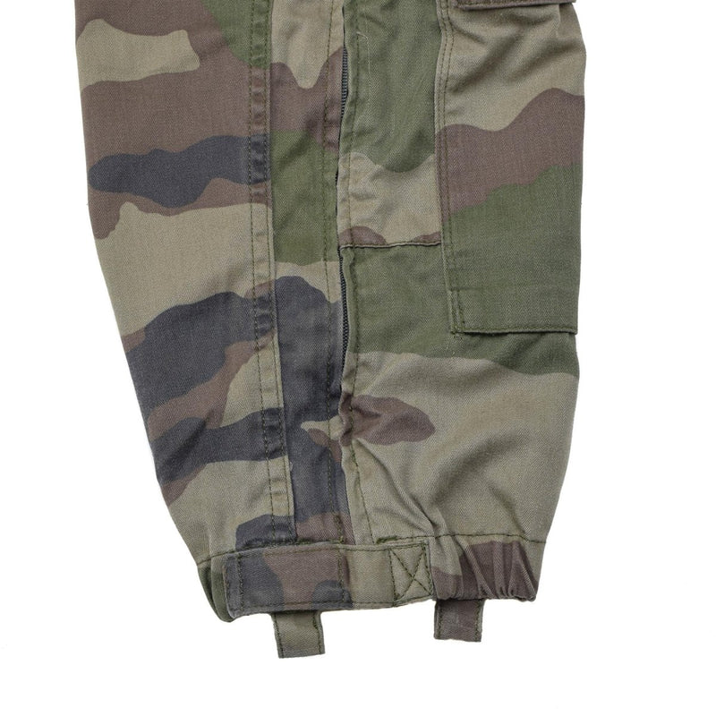 Close-up of genuine French military CCE camouflage coverall pant leg with reinforced stitching and adjustable cuff straps