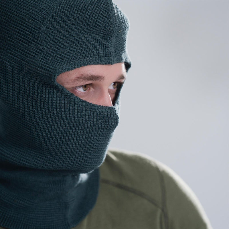 Close-up of a person wearing a gray Swiss Army knitted balaclava covering head and neck for cold weather protection