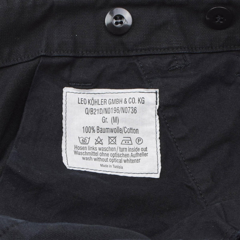 Close-up of black Leo Köhler military bermuda shorts label showing size medium and care instructions.