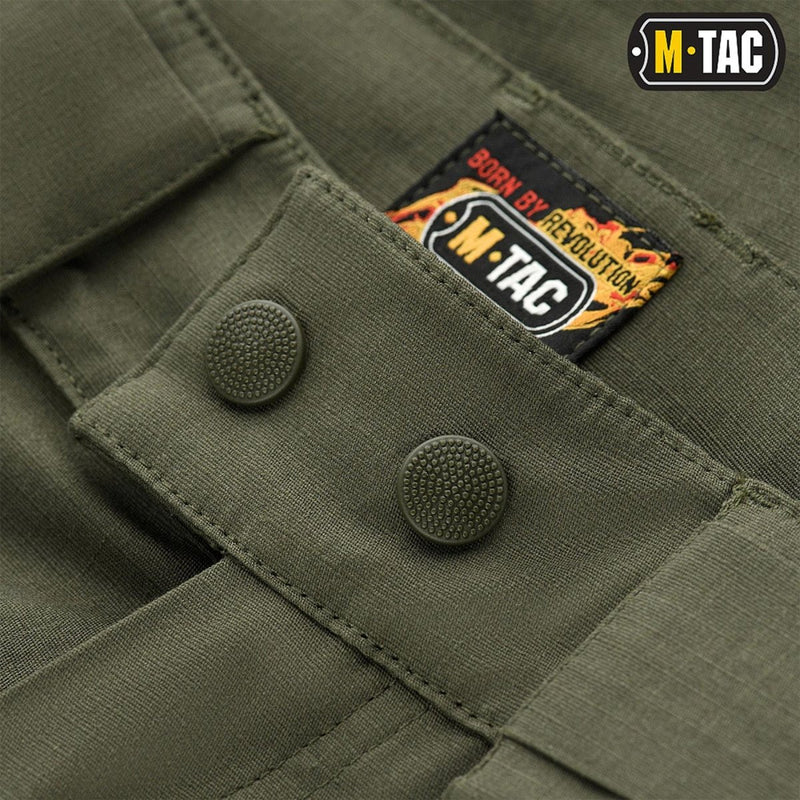 Close-up of olive green M-TAC Army style Bermuda shorts featuring durable buttons and branded label detail.