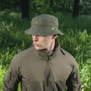 Man wearing M-TAC olive green military style boonie hat and tactical jacket in outdoor forest setting