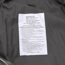 Close-up of label inside MFH Brand US Army M65 field jacket showing size, material, and care instructions.
