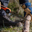 Person using Nordic Pocket Saw cutting a log outdoors while wearing gloves and hiking boots.
