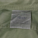 Close-up of a size label sewn on an olive green British army long sleeve military shirt
