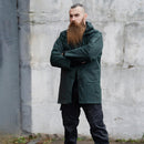Man wearing original green British police waterproof anorak parka with hood and adjustable cuffs standing outdoors
