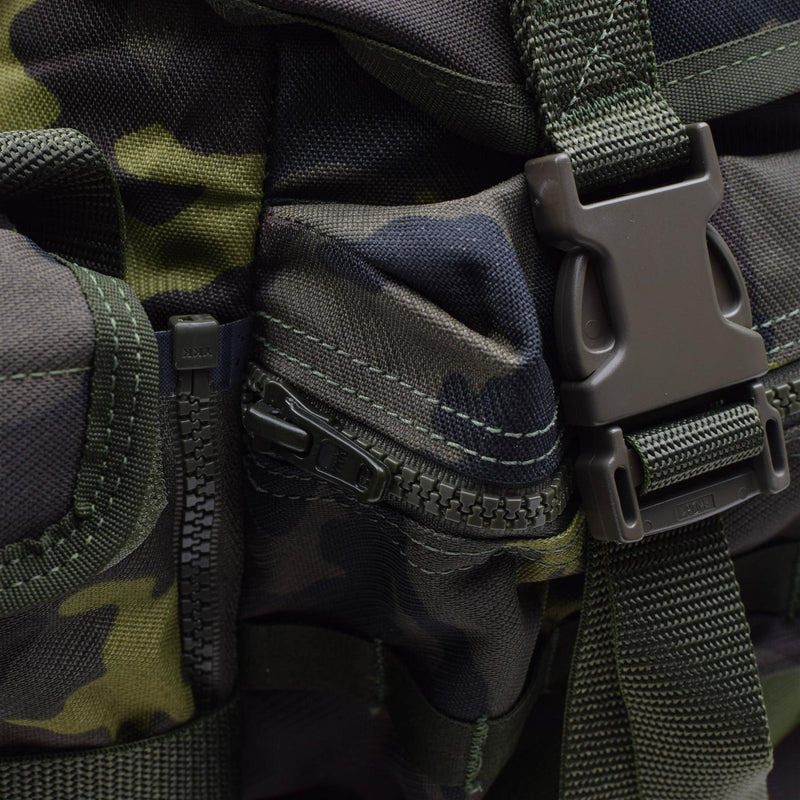 Close-up of original Czech Republic military molle backpack quick release buckle and zipper in woodland camo pattern