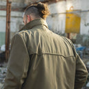 Man wearing khaki vintage Italian military trench coat with high collar in urban outdoor setting