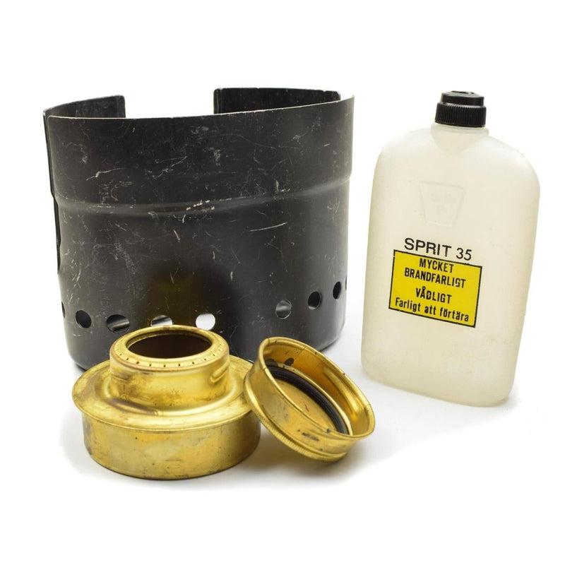 Original Swedish Army Trangia spirit burner, black metal windshield, and white fuel bottle for outdoor cooking kit