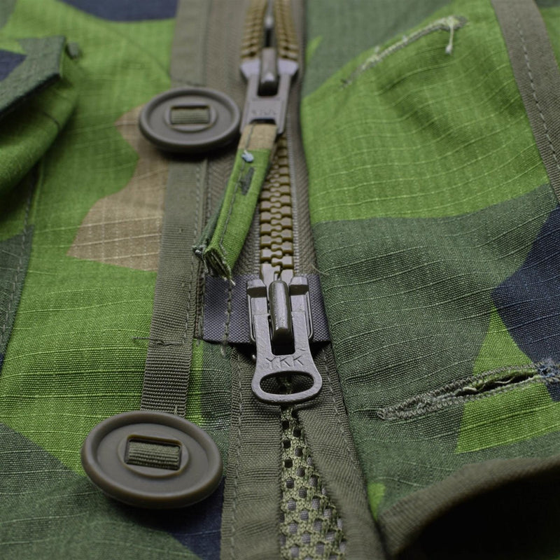Close-up of green splinter camo TACGEAR military commando smock jacket with YKK zipper, buttons, and ripstop fabric details