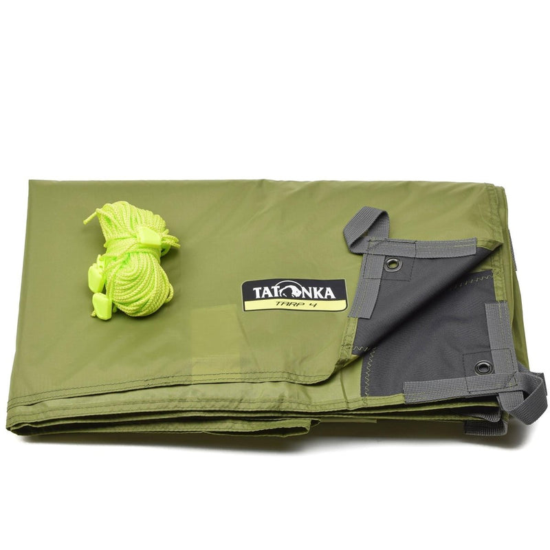 Folded olive green Tatonka waterproof tarp shelter with reinforced corners and attached guy line rope.